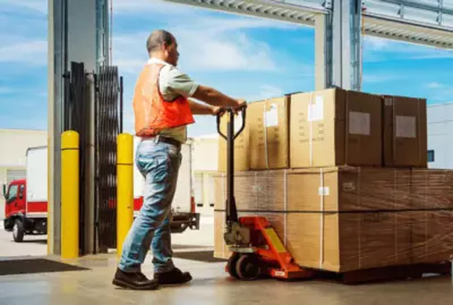 Man moving boxes in warehouse with pallet jack